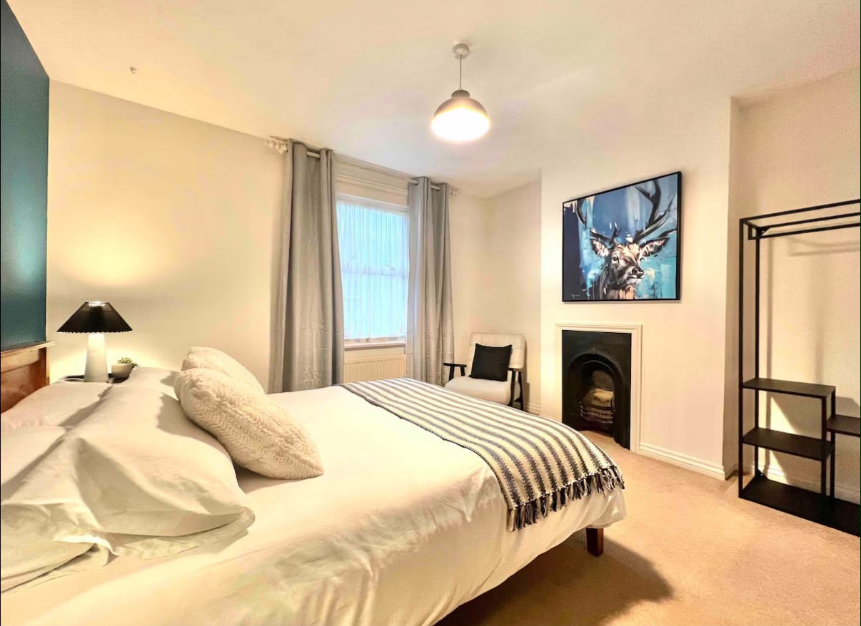 Bright, restful bedroom with feature artwork and fireplace